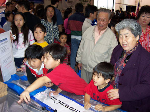 Kids enjoying a game of darts at the ChinatownConnection.com booth
