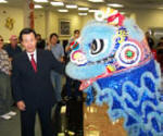 Chairman of Texas First National Bank, Mr. Wu, places a red envelope into the mouth of a lion.